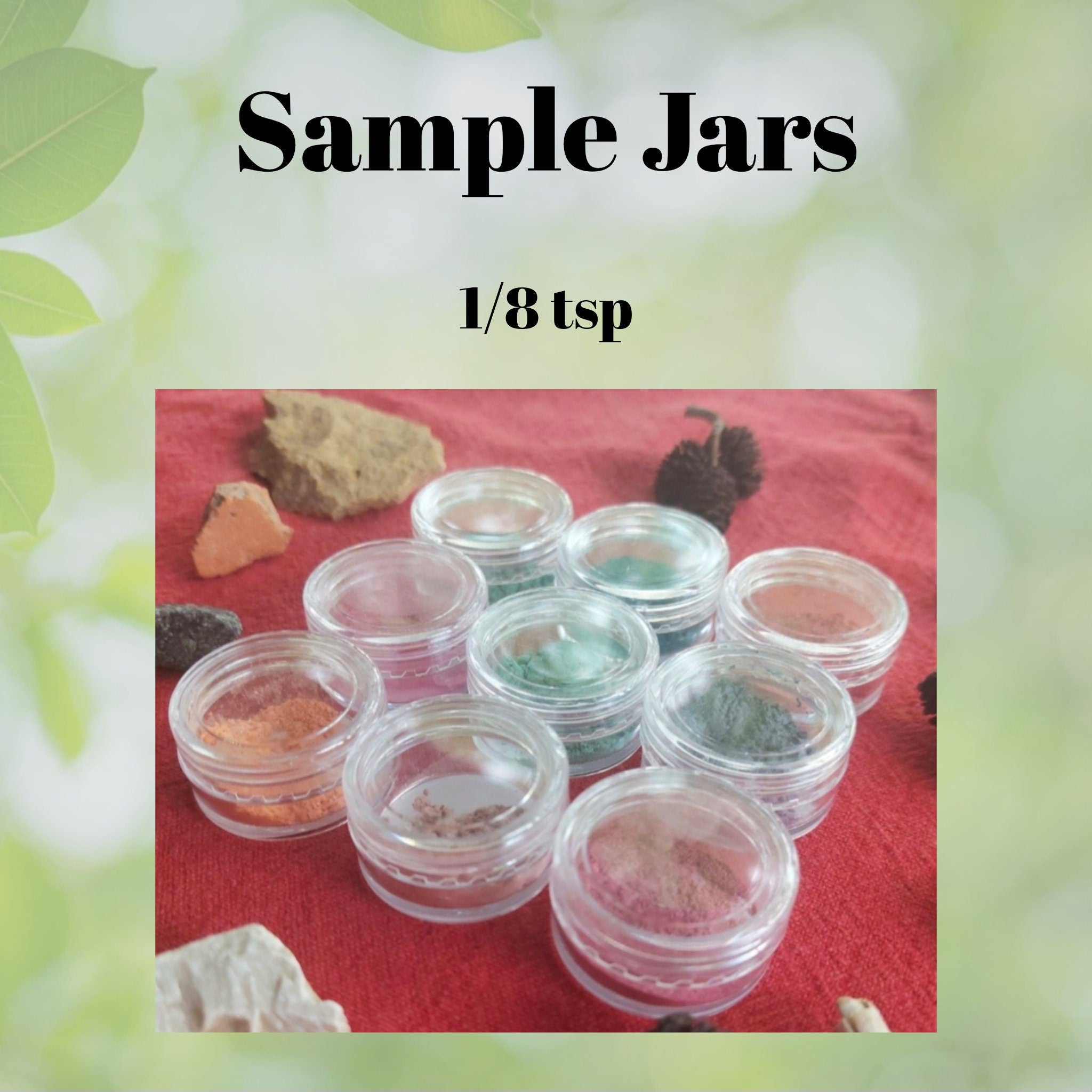 Side view of three small glass jars with vegan mineral eyeshadow in earthy tones, showcasing textured powder surfaces