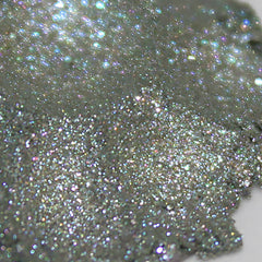 Side view of shimmery grey taupe eye shadow pan with lavender duochrome shift in compact packaging