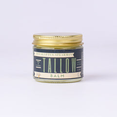 Tallow balm jar with gold lid, blue label, and Lady May text visible