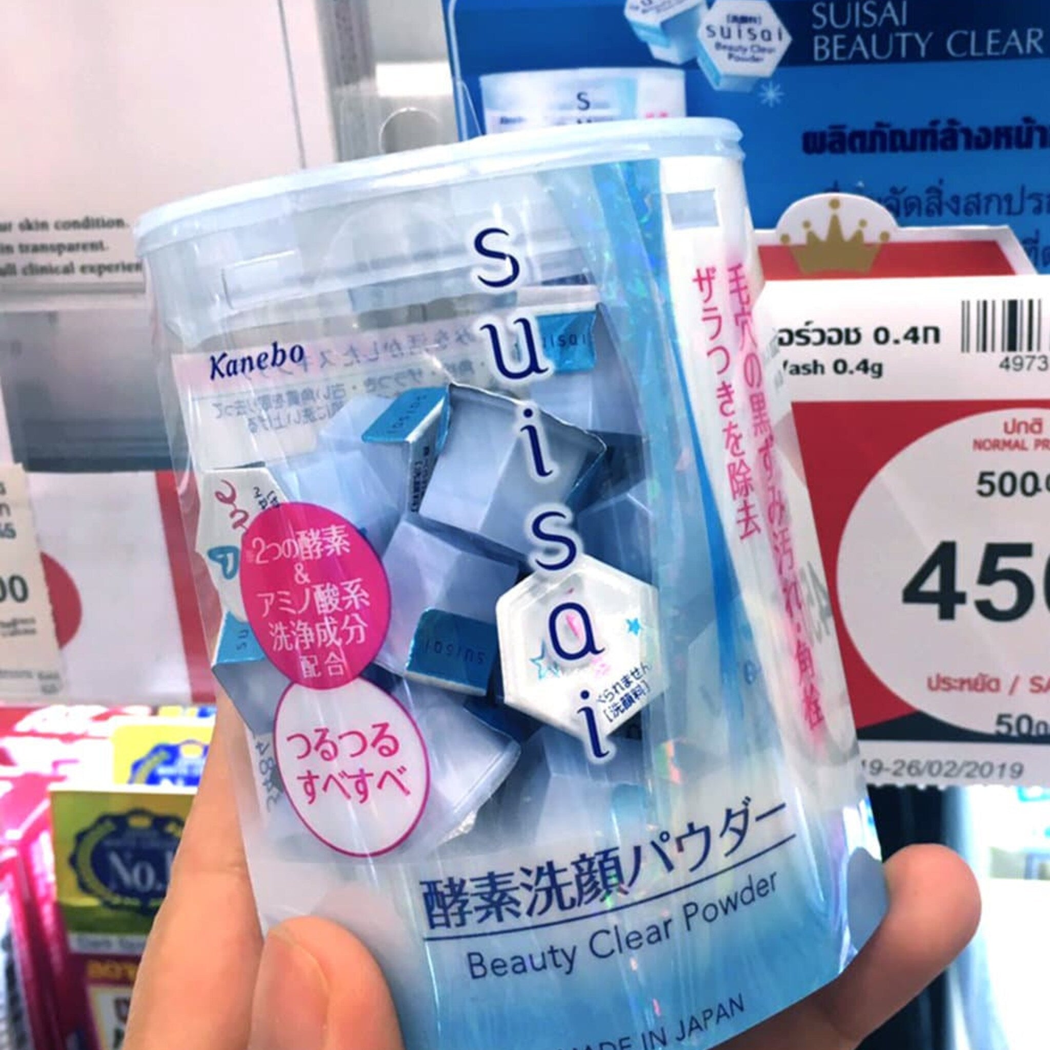 Facial cleanser powder in a clear plastic container with Suisai logo and Japanese text, held in hand