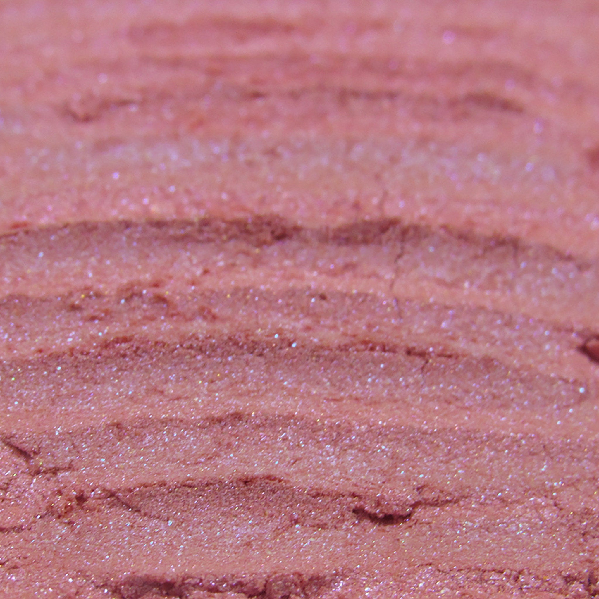 Pink eyeshadow with glitter and textured finish, close-up view