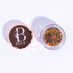 Close-up of warm brown sugar glitter eyeshadow palette with sparkling gold reflect particles