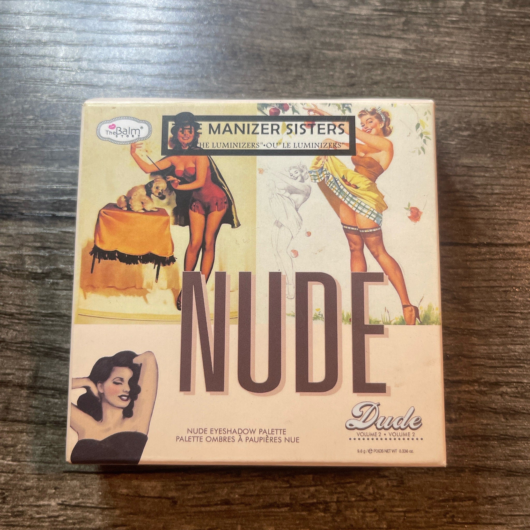 Eyeshadow palette with vintage pin-up art, "Nude" text, and The Balm brand name on packaging