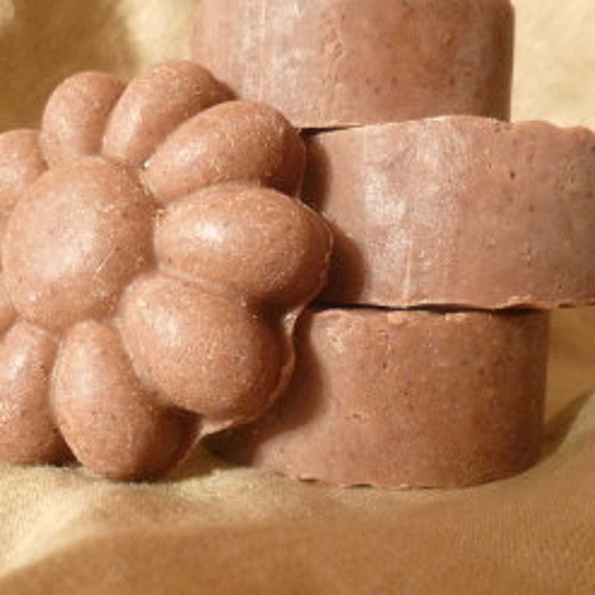 Brown soap bars with organic texture and round shape, stacked together
