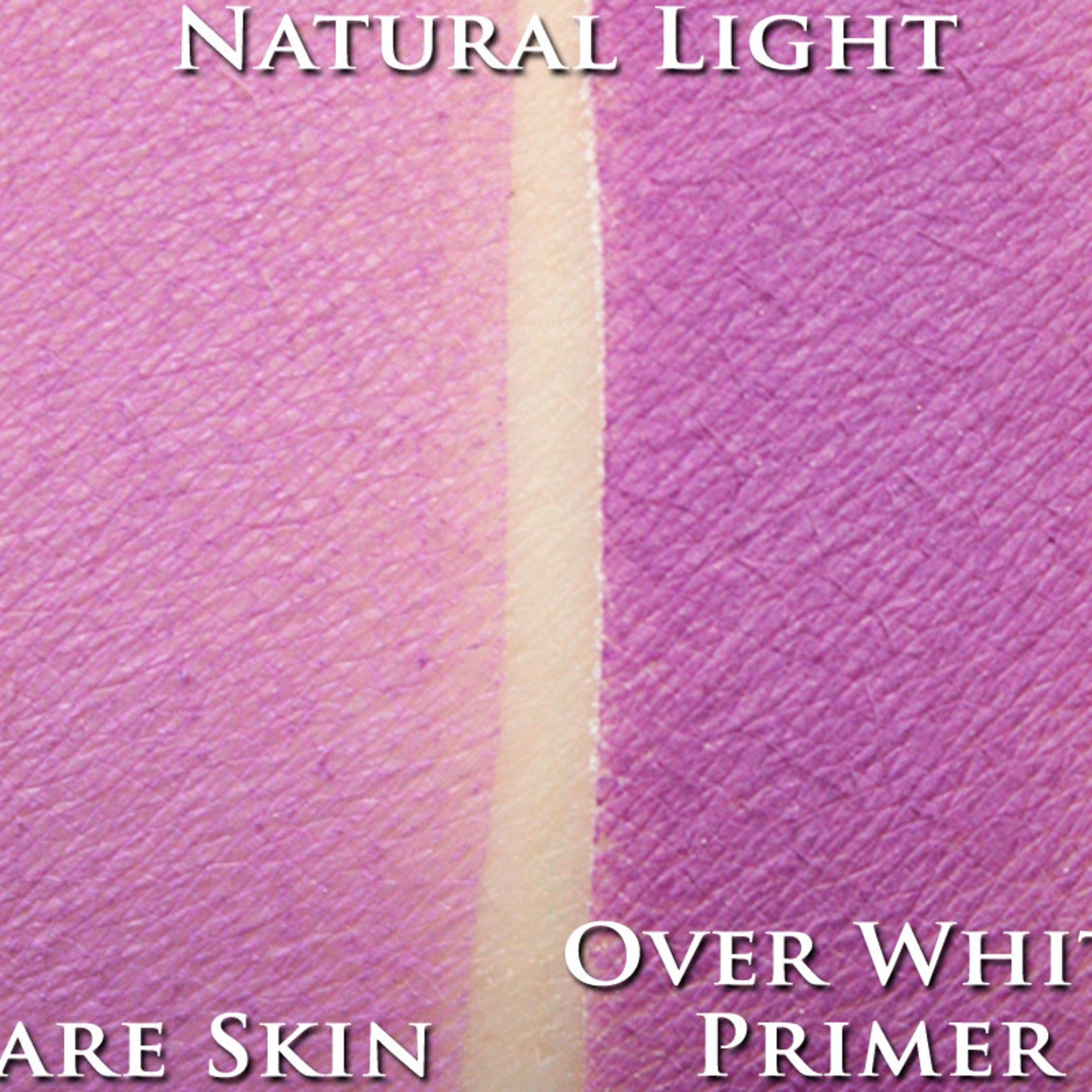Hand applying bright orchid loose powder eyeshadow with a fluffy brush onto eyelid