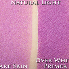Hand applying bright orchid loose powder eyeshadow with a fluffy brush onto eyelid