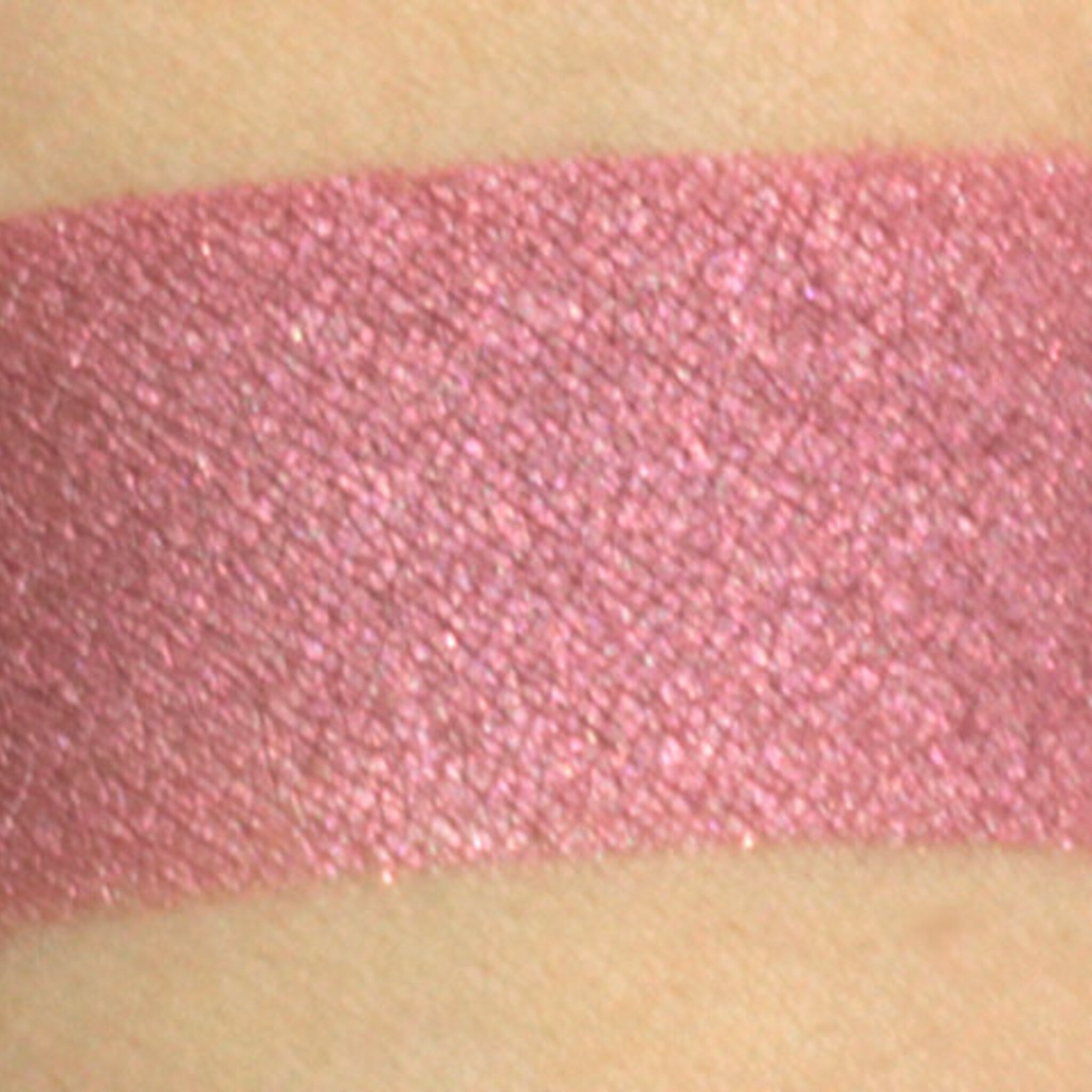 Side view of Pixie Vegan Mineral Eyeshadow in shimmering rose with pink and turquoise flecks, showing compact texture.