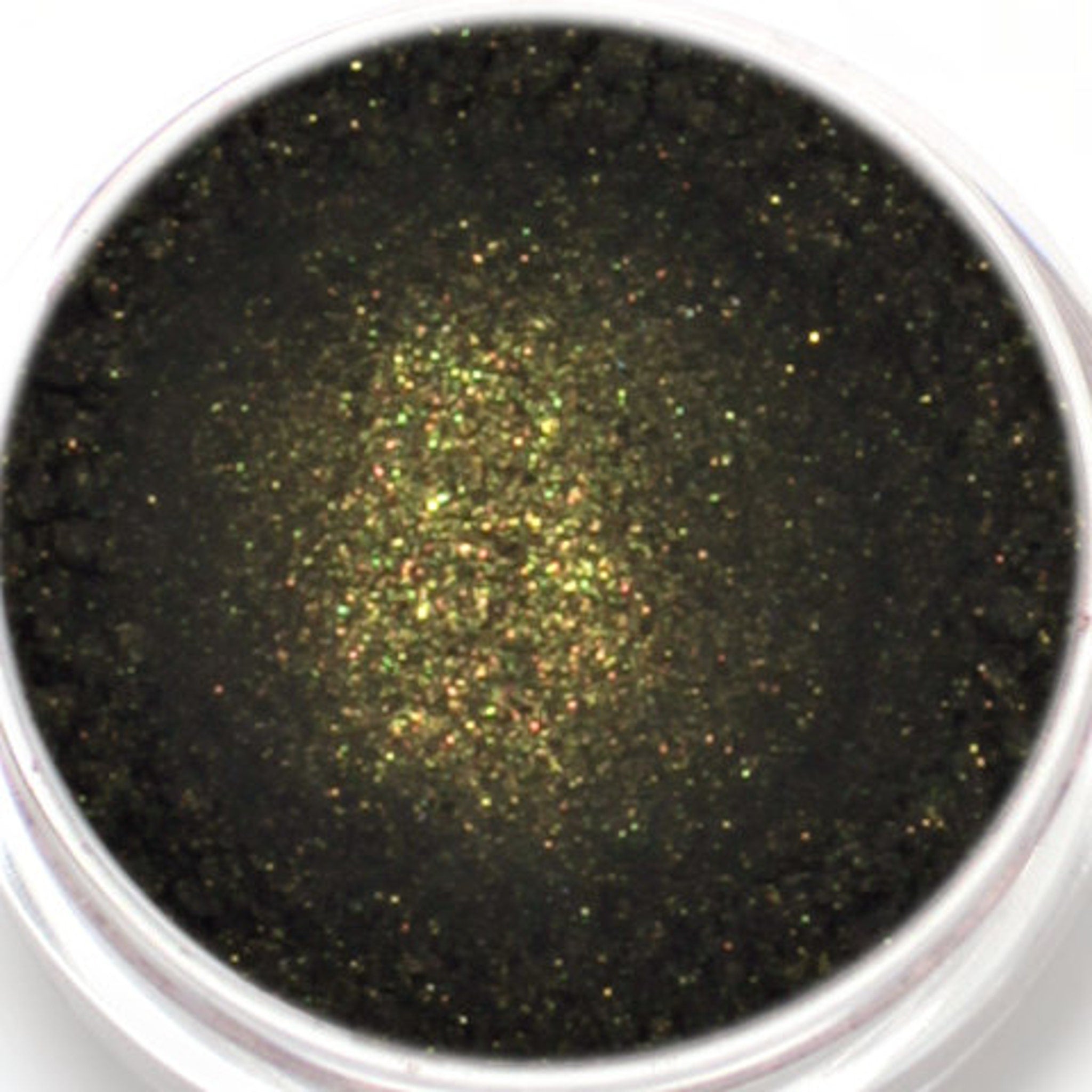 Close-up of black mineral eyeshadow with intense gold shimmer particles in compact pan