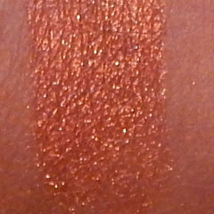 Close-up of vibrant fiesta mineral eyeshadow with shimmering pigments in a compact pan
