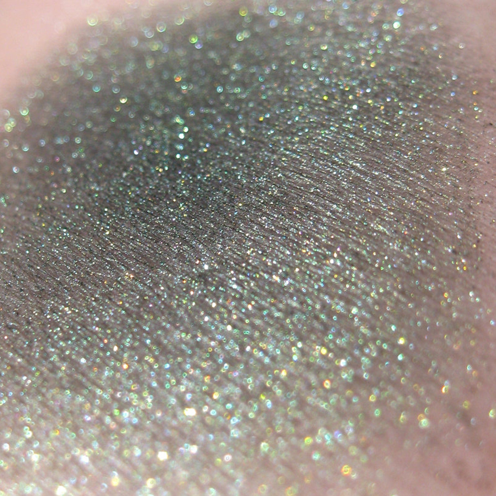 Side view of Vegan Halloween Snake Charmer Eye Shadow palette showing shimmering green and black shades