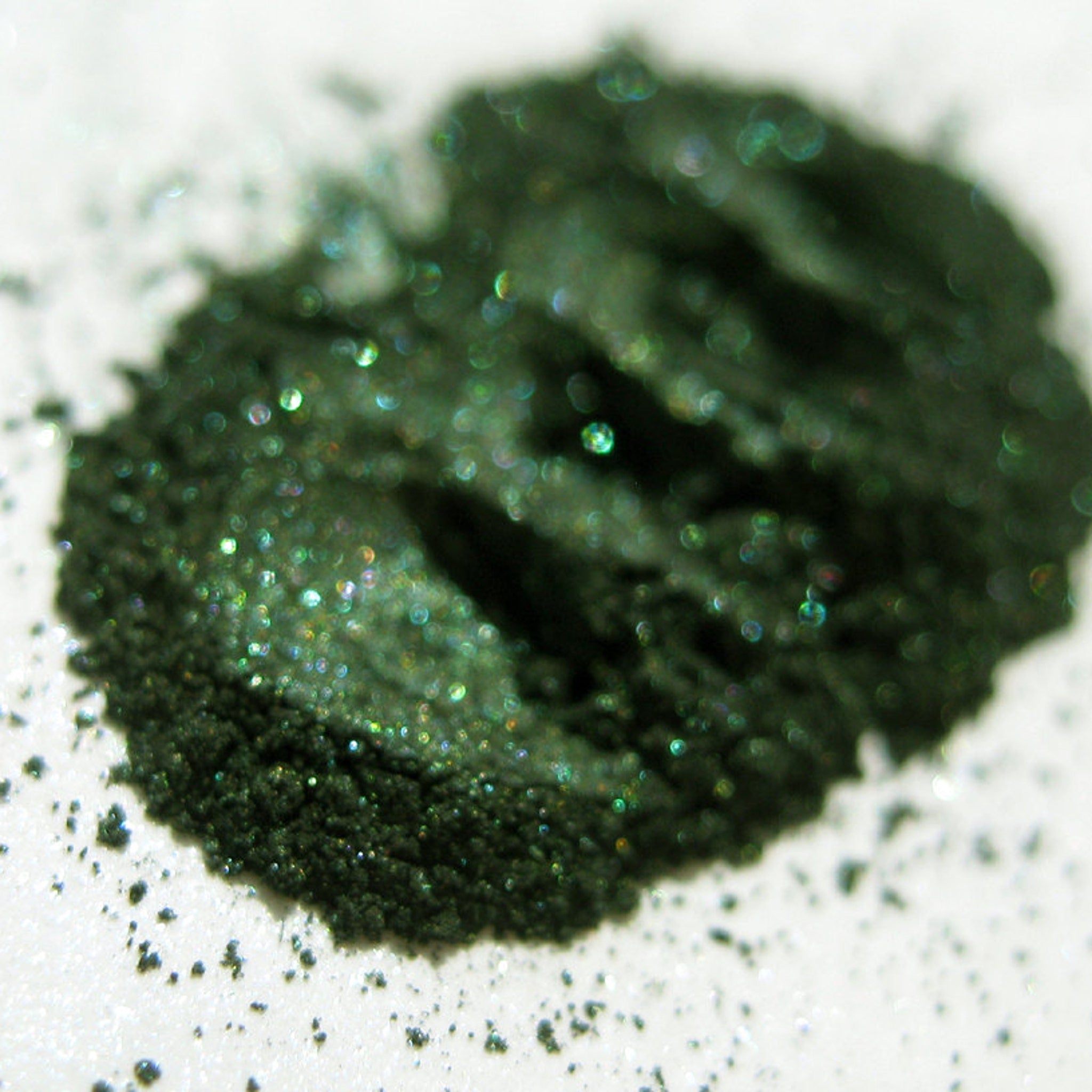 Close-up of shimmery green and black snake-scale patterned eye shadow with vegan formula