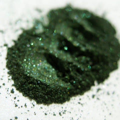 Close-up of shimmery green and black snake-scale patterned eye shadow with vegan formula