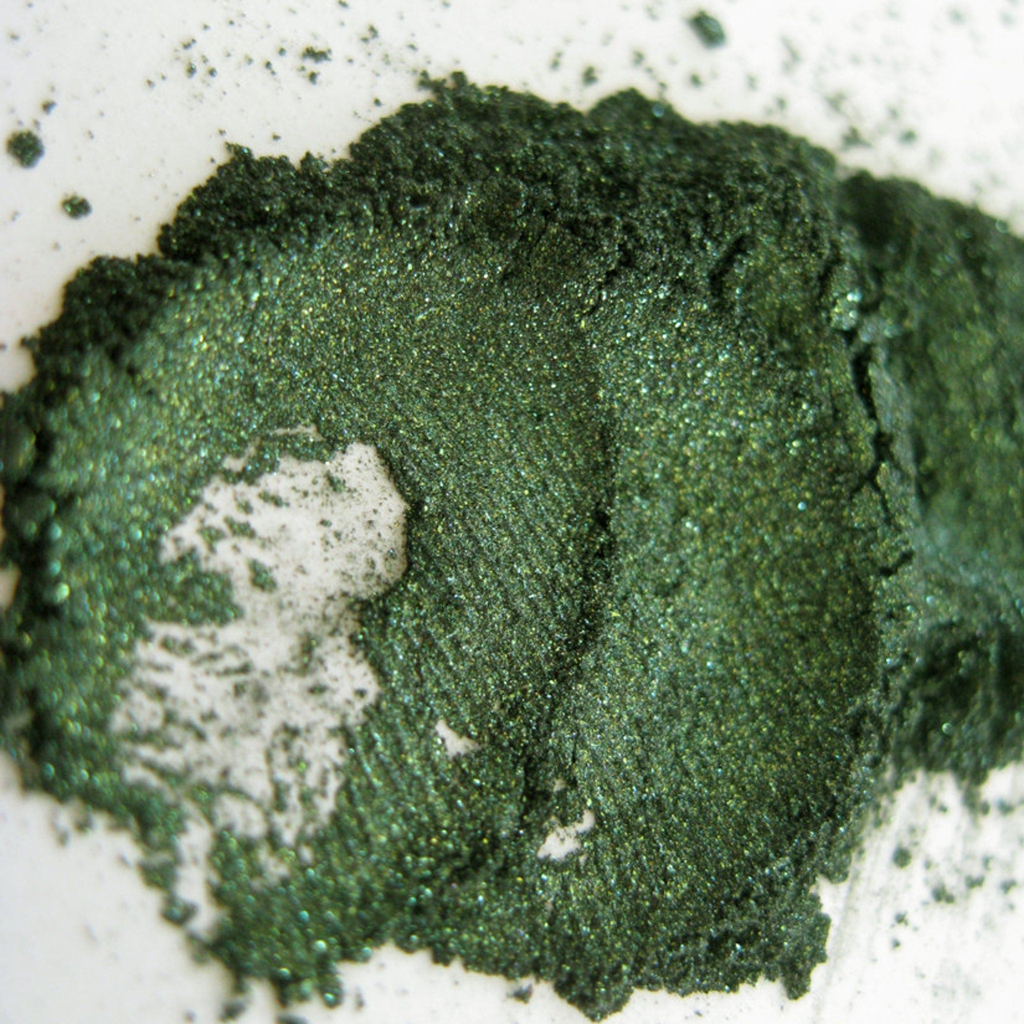 Hand applying shimmering green snake charmer eyeshadow with a blending brush for a smoky Halloween look