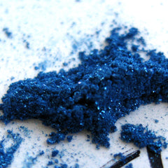 Close-up of iridescent turquoise shimmer and glitter in royal blue loose mineral eyeshadow