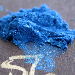 Vibrant royal blue loose mineral eyeshadow with iridescent turquoise shimmer and glitter in a clear jar