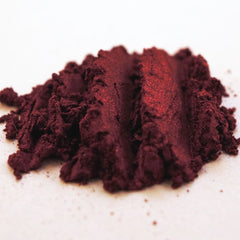 Hand applying blood red metallic loose eyeshadow with brush for vampy Halloween look