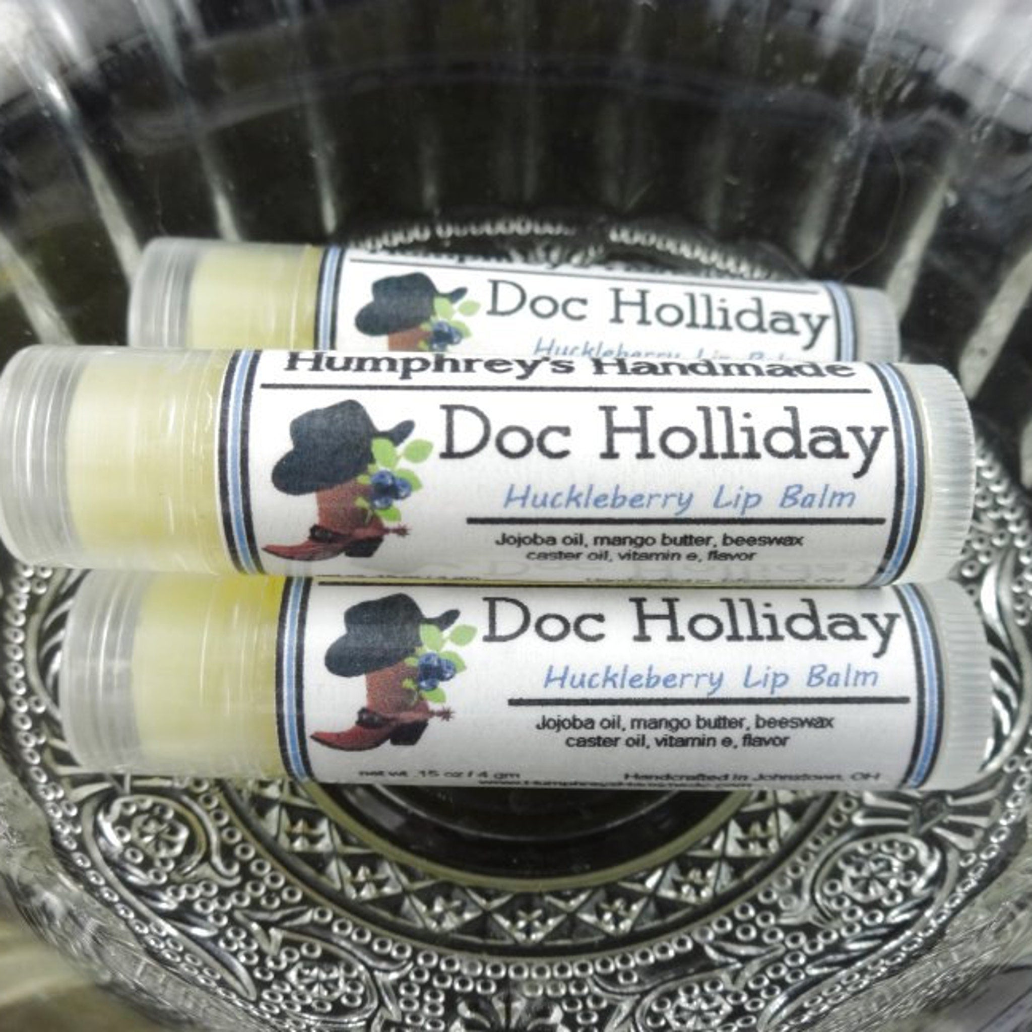 Lip balm tubes with yellow balm, clear plastic, and Doc Holliday label with cowboy hat logo