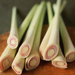 Lemongrass stalks with green and white color, cross-section showing pink rings, on a wooden surface