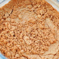 Small glass jar with black sifter lid containing pigmented mineral eye shadow in a rich, velvety powder finish.