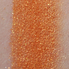 Close-up of pigmented mineral eyeshadow powder in a jar with sifter lid, showcasing rich color payoff and fine texture