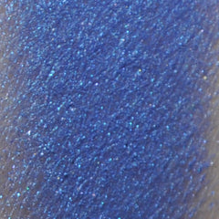 Close-up of pigmented mineral eyeshadow in a jar with sifter lid, showcasing fine powder texture and vibrant color payoff