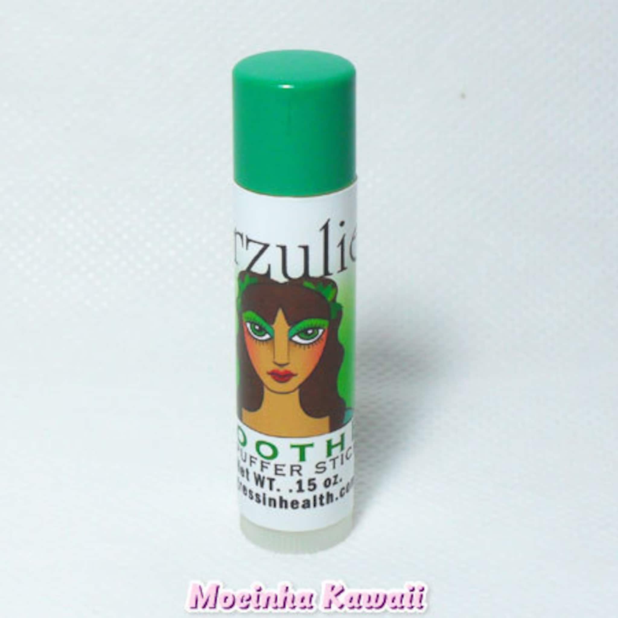 Eye balm tube with green cap, white label, and Erzulie Cosmetics branding