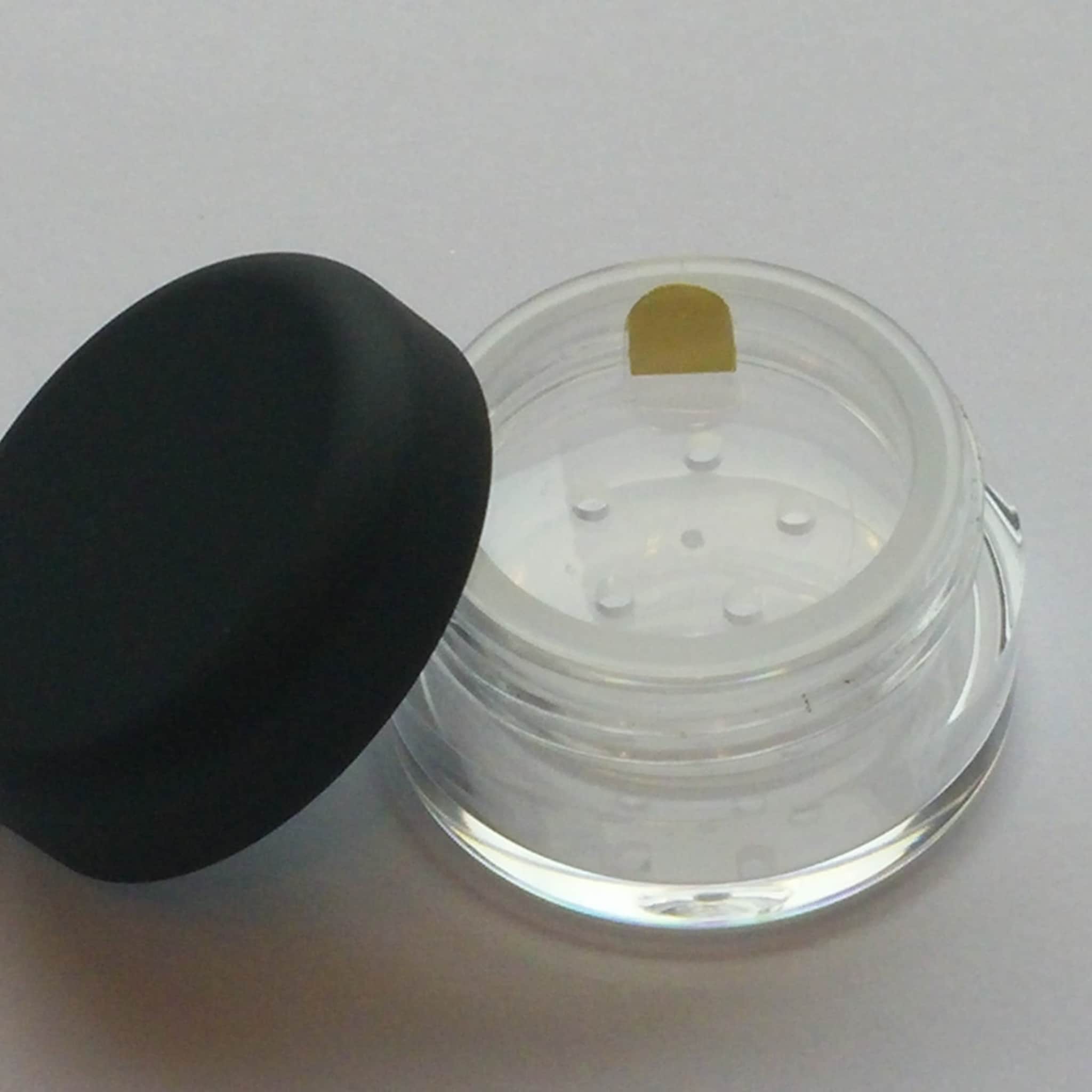 Clear plastic jar with black lid and yellow sticker on top