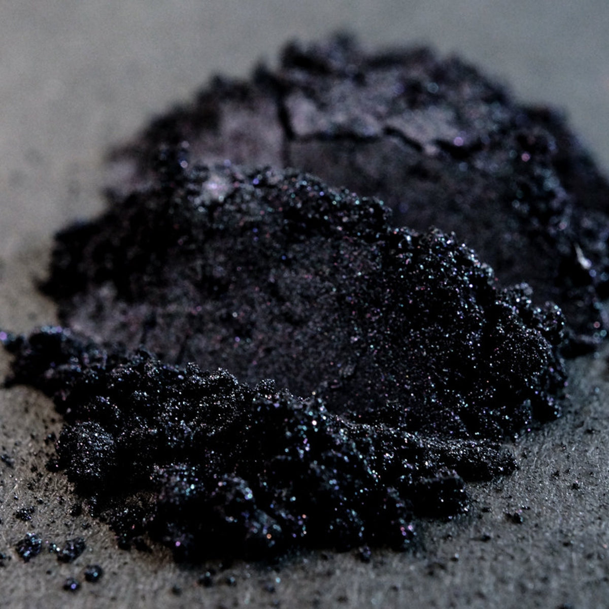 Metallic black loose mineral eyeshadow with iridescent gunmetal shimmer in a sleek jar