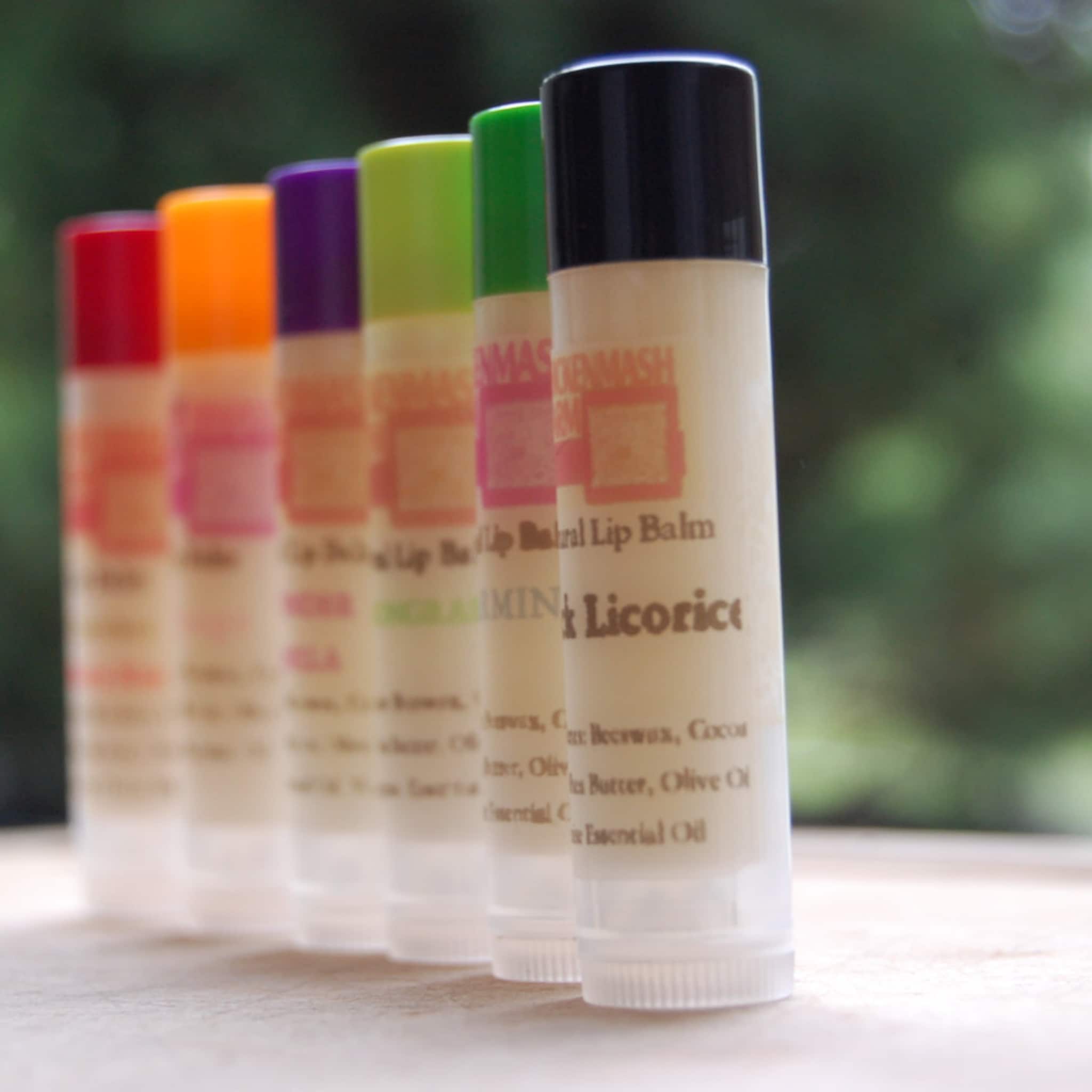Lip balm tubes with colorful caps, Chickenmash Farm brand visible, lined up on a surface