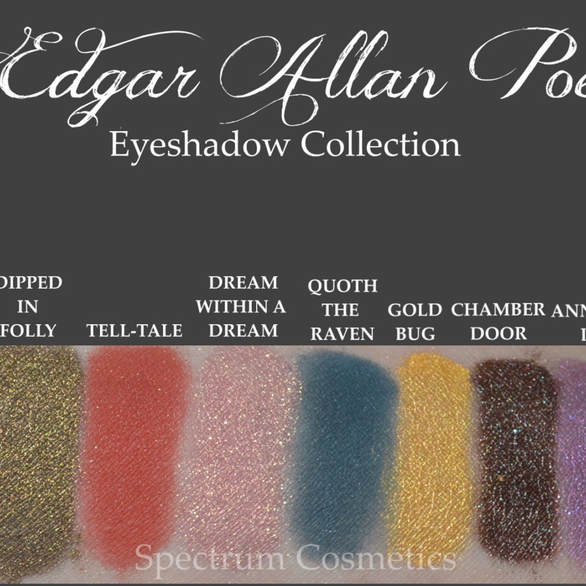 Open compact showing dusky blue matte eyeshadow pan with embossed raven design, Poe-inspired Halloween makeup
