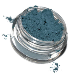 Close-up of dusky blue matte eyeshadow pan showing smooth, velvety texture and rich pigment