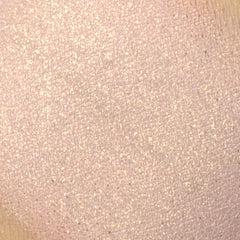 Woman applying light golden pink vegan mineral eyeshadow with fingertip to eyelid