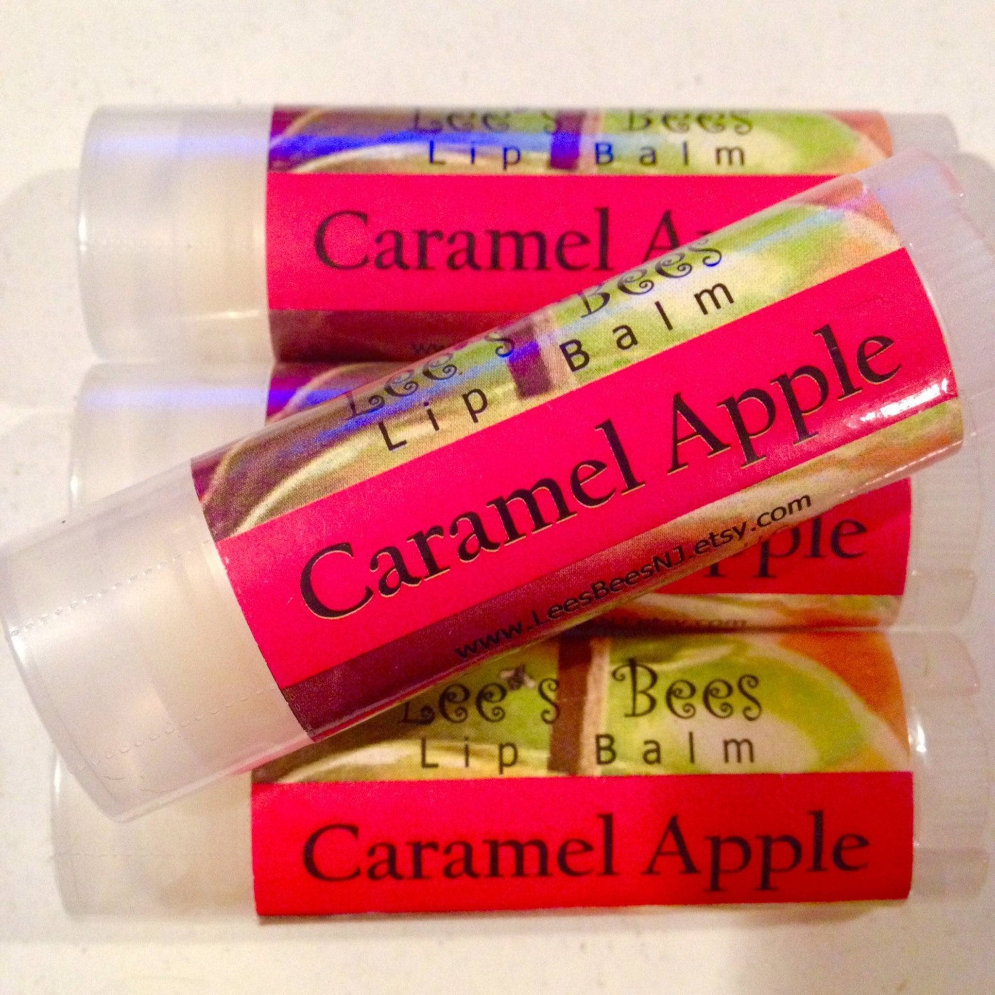 Lip balm tubes with red labels, clear plastic, and "Caramel Apple" text