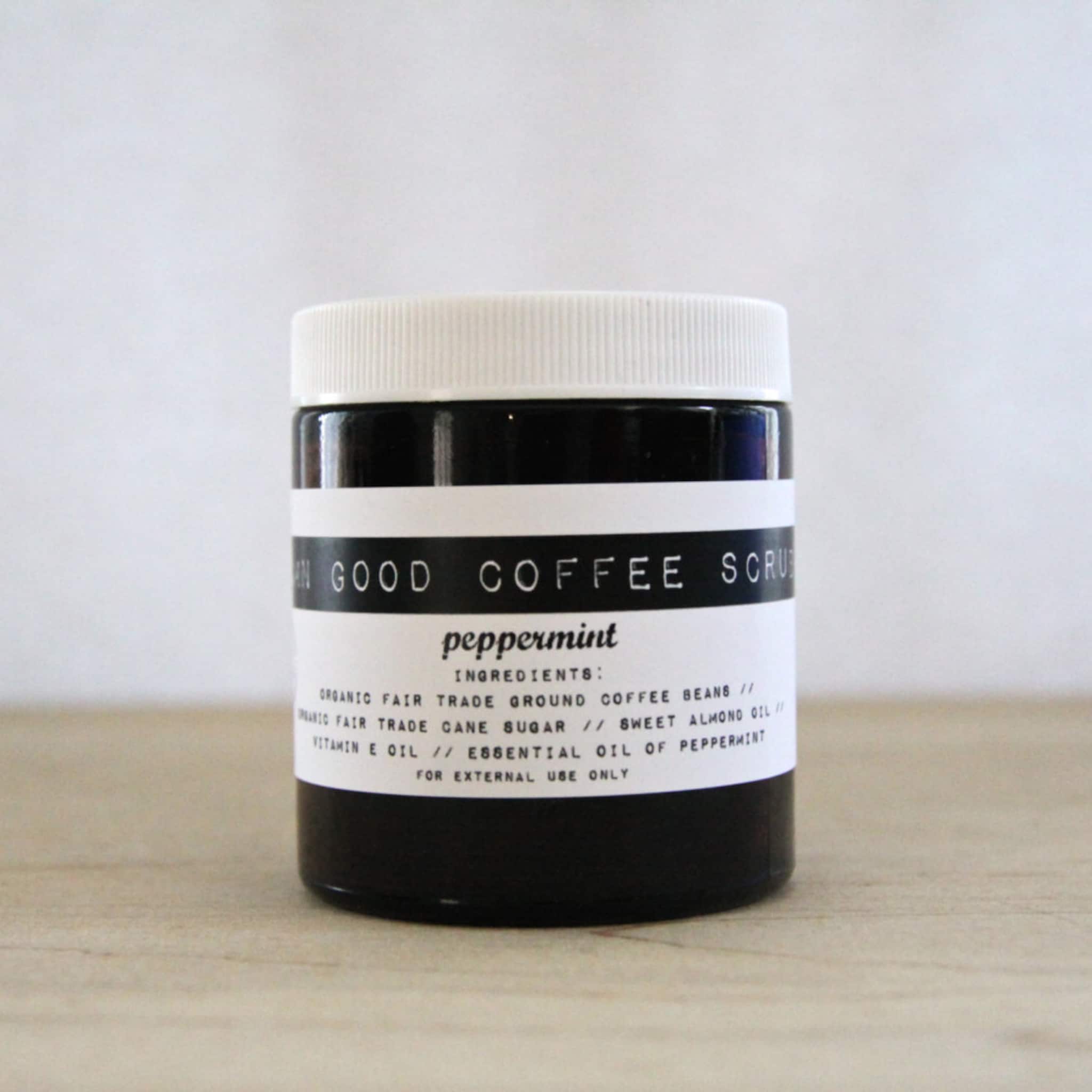 Coffee scrub jar with white lid, black body, and white label with text