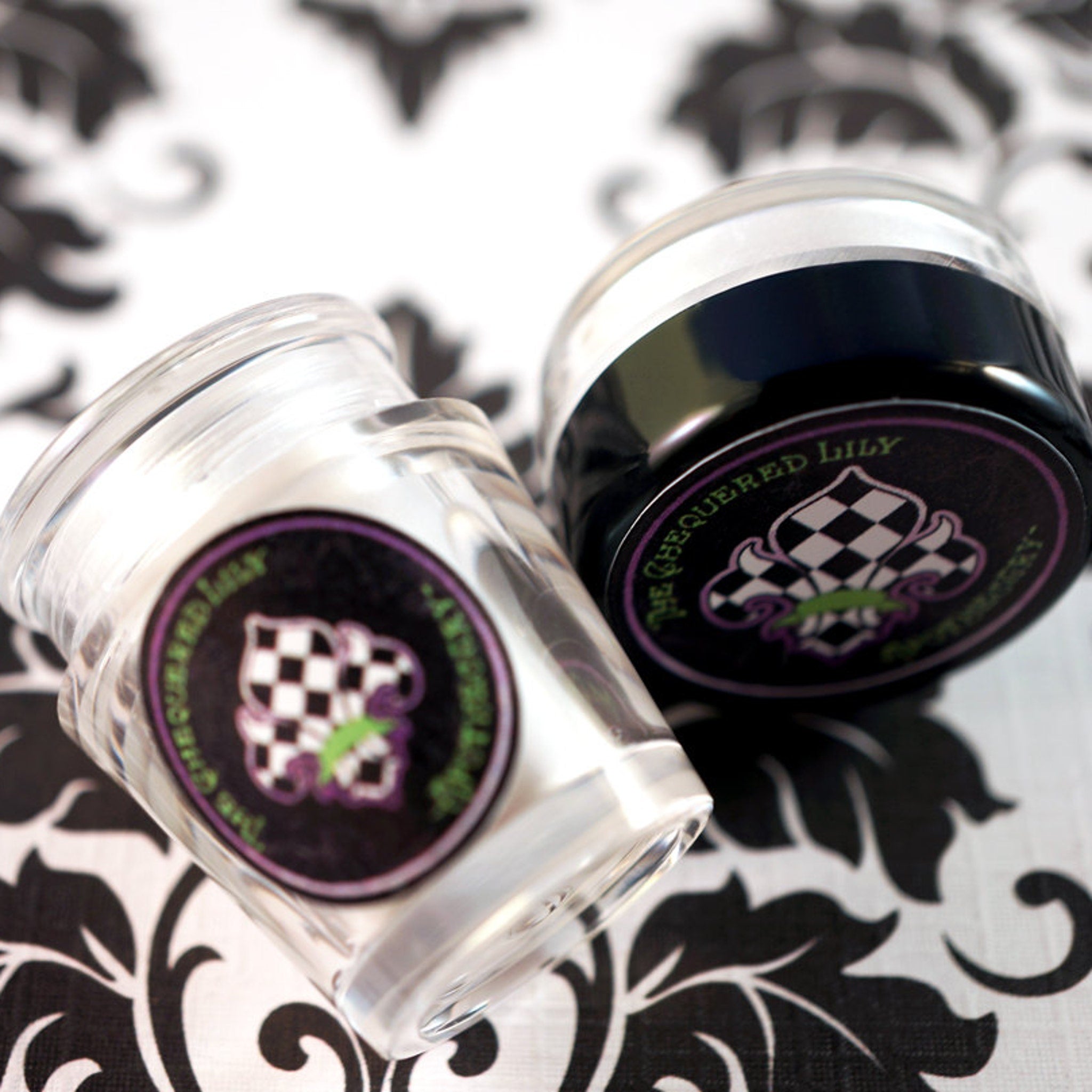 Glass jars with black and white checkered labels, The Chequered Lily brand visible