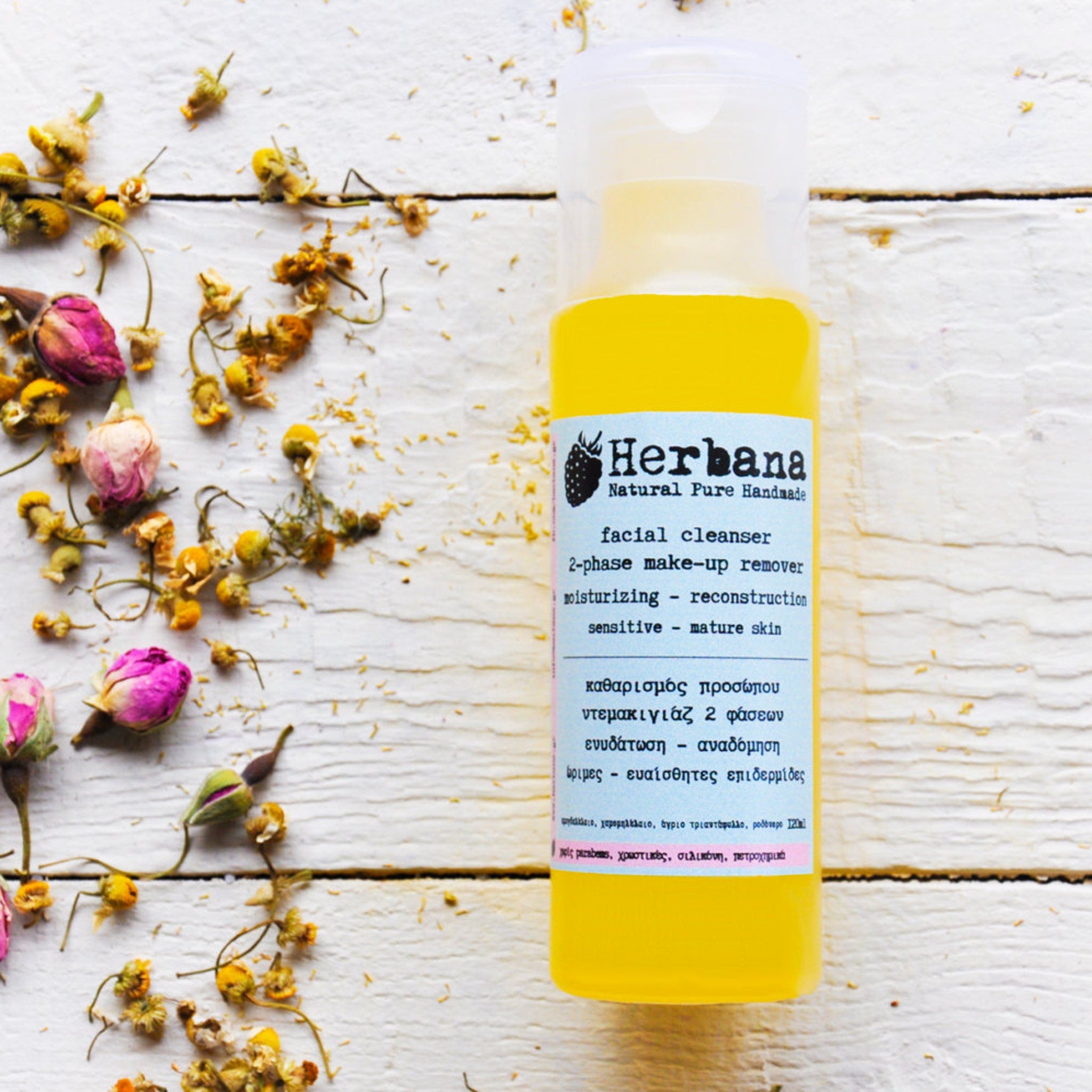 Facial cleanser bottle with yellow liquid, white cap, and Herba label on wooden surface