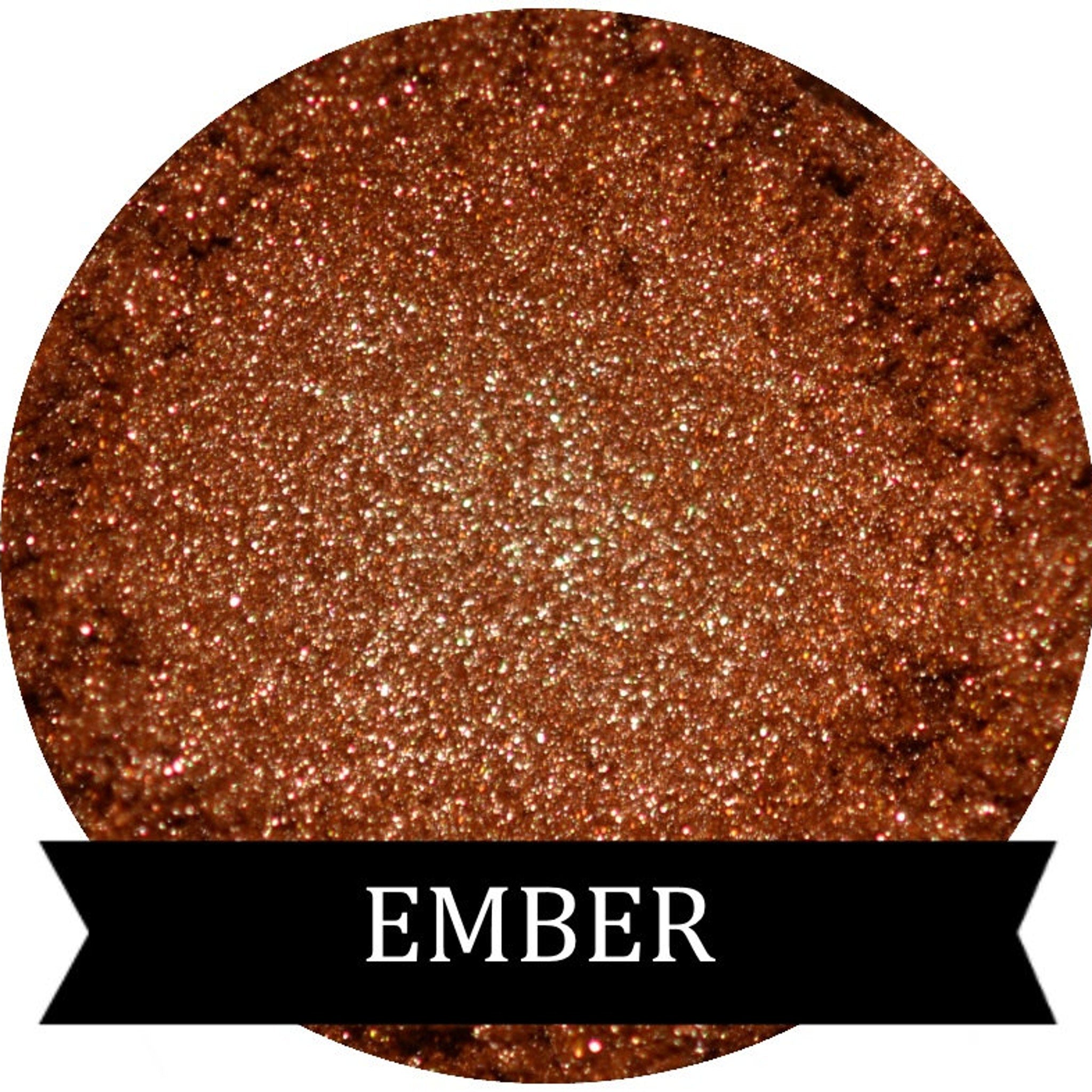 Metallic copper orange eyeshadow in ember shade with reflective shimmer, shown in compact pan.