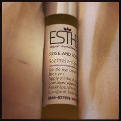 Eye cream bottle with white label, black text, and ESTH logo, shown in fabric setting