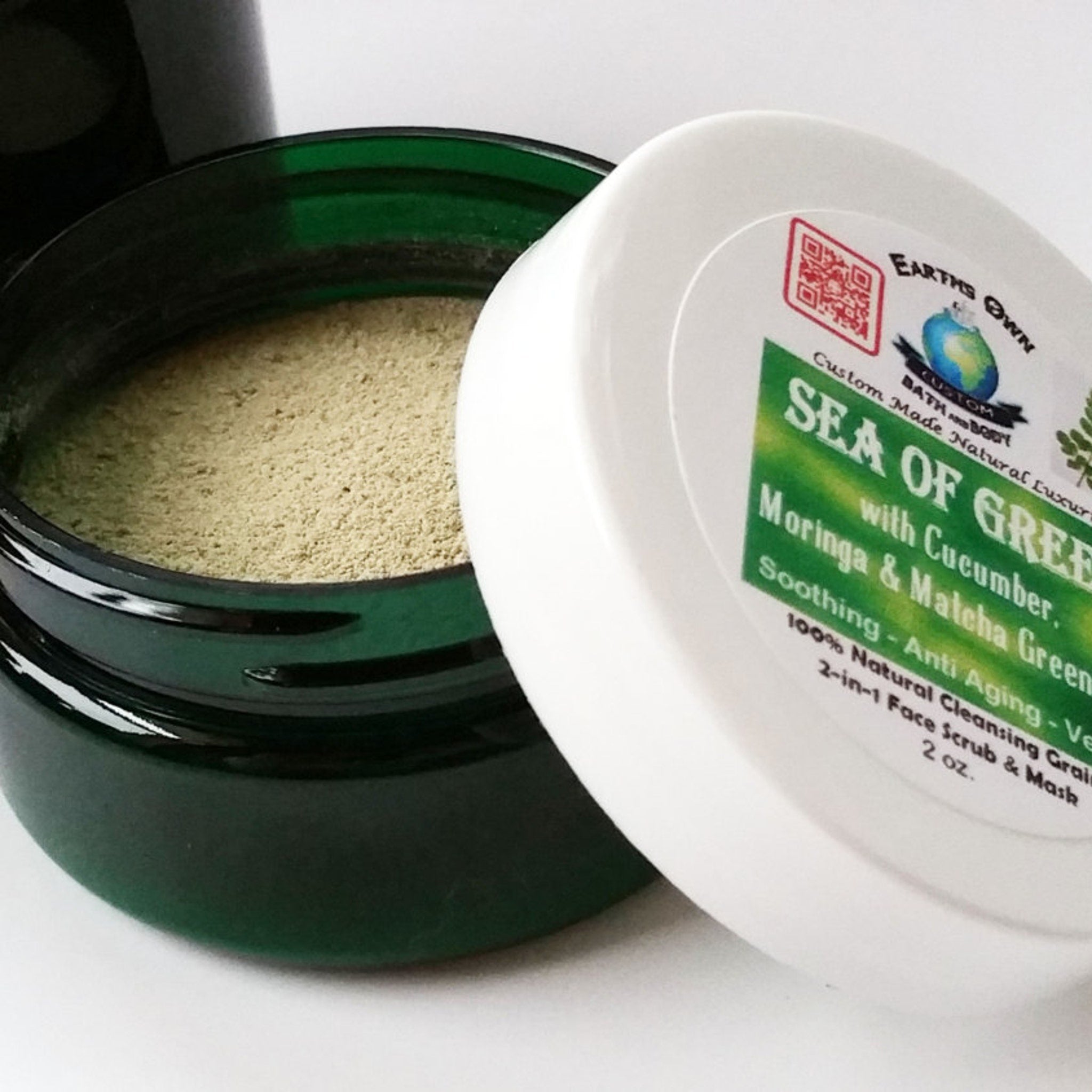 Facial cleanser jar with green powder, dark green glass, and white lid with Earth's Own text