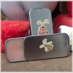 Metal tins with decorative decals, gray and silver, open to show pink contents