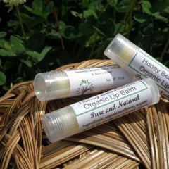 Lip balm tubes with white labels, clear plastic caps, and light yellow balm on woven basket